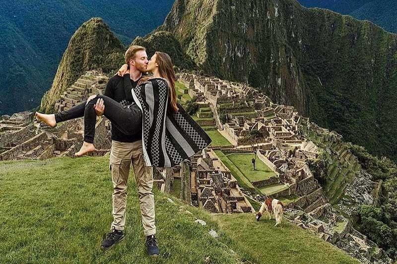 Tourist couple visiting Machu Picchu