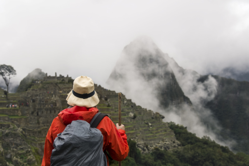 Turista explorando Machu Picchu en un día nublado