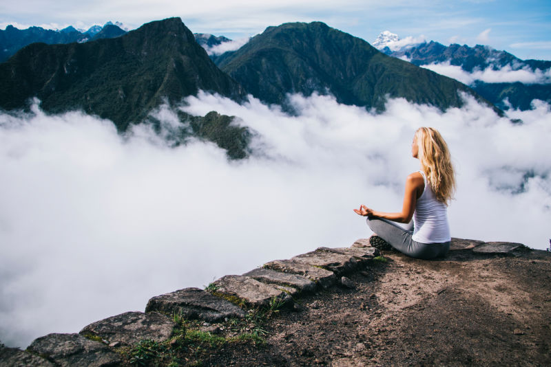 Tourist meditating on the summit of Huayna Picchu