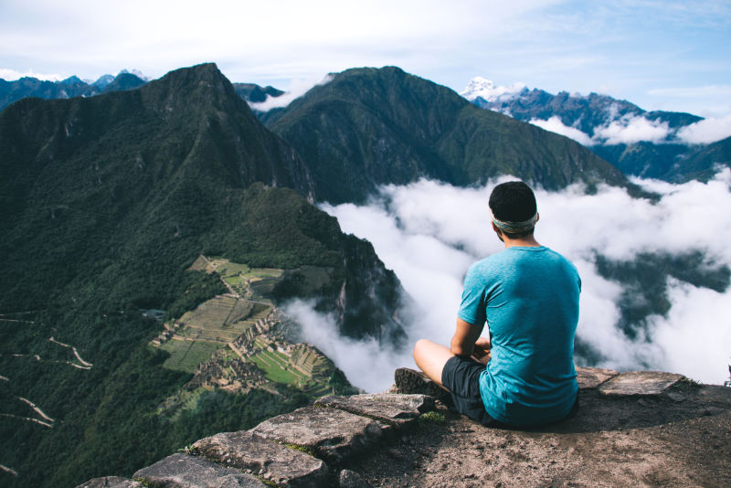 Turista observando la ciudadela Inca desde la cima del Huayna Picchu