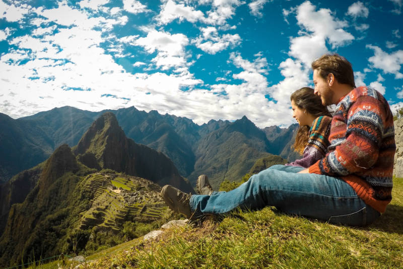 Casal de turistas olhando para Machu Picchu