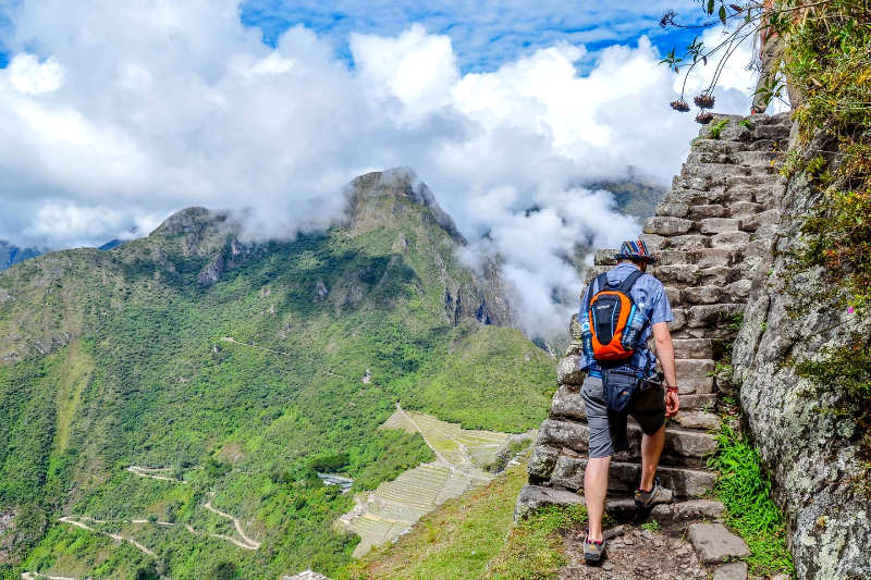 Visitor climbing up the stone steps to Huayna Picchu