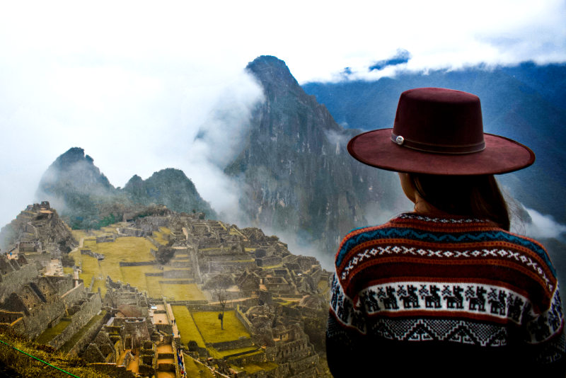 Turista observando as construções da cidadela de Machu Picchu