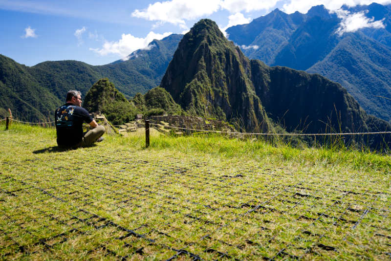 Turista sentado observando a Cidadela Inca