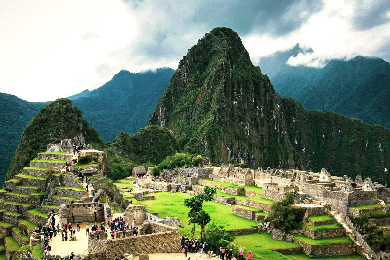 Tourists walking around the archaeological site of Machu Picchu