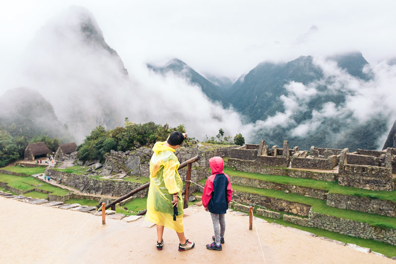 Girl listening to an explanation about Machu Picchu on a rainy day