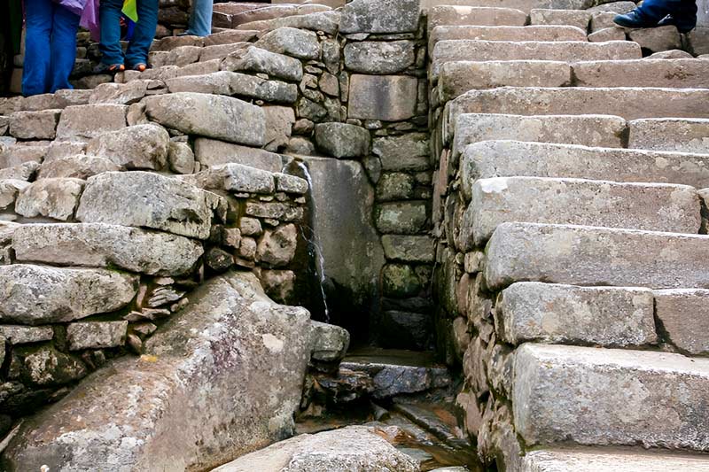 Water fountain under the stone steps at Machu Picchu