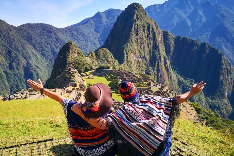 Tourist couple admiring Machu Picchu