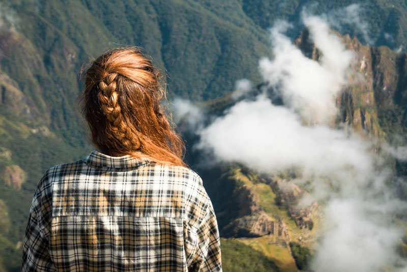 Traveler observing the Inca citadel from Machu Picchu Mountain